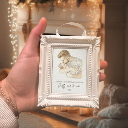 A close-up of a watercolor Christmas ornament style frame, the Personalized First Christmas As Dad Frame Ornament is a custom hand painted gift for new dads.