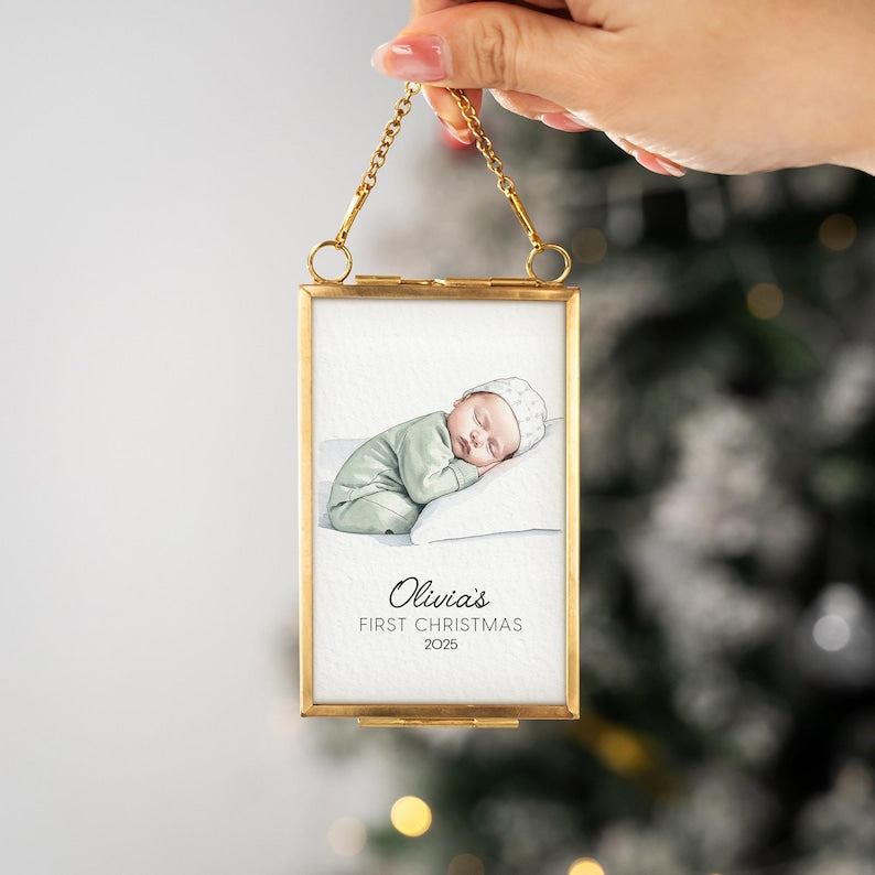 A close-up of a newborn Christmas ornament, the Personalized Watercolor Baby Portrait Frame Ornament is an ideal gift for new parents.
